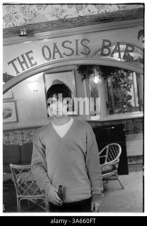 LIAM GALLAGHER, BIER, JUNG, PORTRÄT, OASE, 1994: Liam Gallagher aus Oasis trinkt eine Flasche Bier in der Oasis Bar des King's Head Hotels in Newport, Wales, 3. Mai 1994. Die Band war auf ihrer ersten Headline UK Tour, um ihre zweite Single Shakermaker zu unterstützen. Foto: Rob Watkins. Im Jahr 1994 begann Oasis mit ihrem Debütalbum definitiv Maybe in die britische Musikszene einzutauchen und den Britpop mit roher Energie und anthemischen Songs neu zu definieren. Geführt von den Brüdern Liam und Noel Gallagher, machten ihre Einstellung, ihre Swagger und Hits wie Live Forever sie zu Instant-Rock-Ikonen. Stockfoto