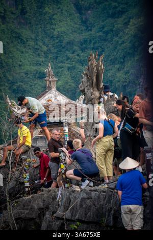 Touristen klettern auf die Drachenstatue auf der Spitze des Hang Mua Kalksteinbergs, Ninh Binh Stockfoto