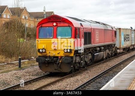 Güterzug der DB Cargo Class 66, der durch den Bahnhof Peterborough, Cambridgeshire, England, Großbritannien fährt Stockfoto