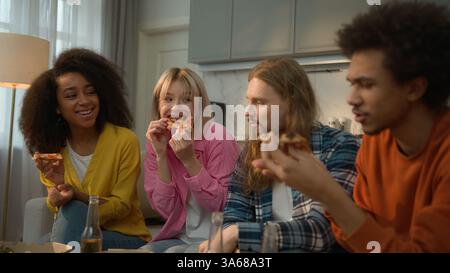 Sorglos multirassisch vier Leute multiethnische Freunde Vielfalt afroamerikanische Männer Männer männliche weibliche Mädchen Frauen sprechen Party zu Hause essen Pizza Stockfoto