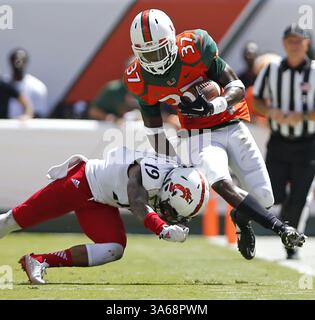 11. Oktober 2014 - Miami Gardens, FL, USA - Miami Hurricanes Defensive Back Ladarius Gunter (37) lässt eine Interception zurück, als Cincinnati Bearcats Wide Receiver Shaq Washington (19) während des ersten Quartals am Samstag, 11. Oktober 2014 im Sun Life Stadium in Miami Gardens, Florida, verteidigt (Kreditbild: © Al Diaz/MCT/ZUMA Wire) Stockfoto