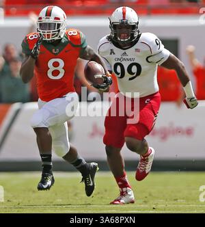 11. Oktober 2014 - Miami Gardens, FL, USA - Duke Johnson von Miami Hurricanes läuft für einen 80-Yard-Touchdown als Cincinnati Bearcats' Jerrell Jordan im ersten Quartal am Samstag, 11. Oktober 2014, im Sun Life Stadium in Miami Gardens, Florida. (Kreditbild: © Al Diaz/MCT/ZUMA Wire) Stockfoto