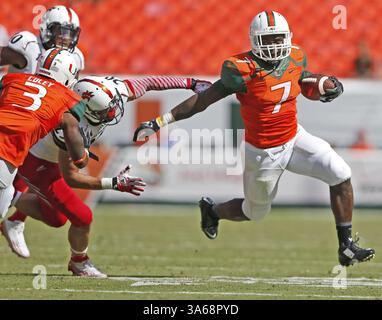11. Oktober 2014 - Miami Gardens, FL, USA - Miami Hurricanes Running Back Gus Edwards (7) entzieht sich einem Verteidiger auf seinem Weg, um im vierten Quartal am Samstag, 11. Oktober 2014, im Sun Life Stadium in Miami Gardens, Florida, gegen die Cincinnati Bearcats zu schießen (Credit Image: © Al Diaz/MCT/ZUMA Wire) Stockfoto