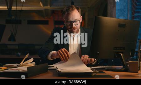 Müde erschöpft ermüdet spät langweiliger Geschäftsmann überarbeitete kaukasische Geschäftsmann Arbeitgeber Scheckpapiere dokumentieren Computer Online Guy Stockfoto