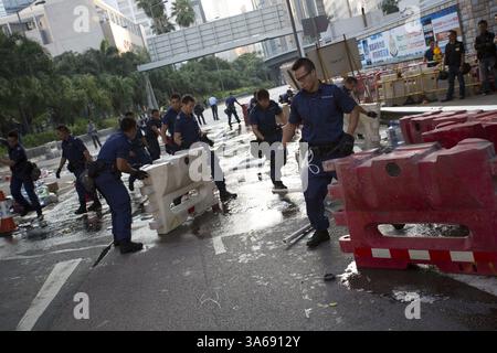 13. Oktober 2014 - Hongkong, China - Polizeibeamte beginnen am 13. Oktober 2014 mit der Beseitigung der Barrikade in Admiralität Pro-Democracy Sit-in in Hongkong.die Spannungen in Hongkong sind immer noch hoch, da die Pro-Demokratie-Bewegung die Straßen in Hongkong besetzt hat und offene Wahlen und den Rücktritt von Hongkongs Chef Leung Chun Ying forderte. (Bild: © Raul Ariano/ZUMA Wire/ZUMAPRESS.com) Stockfoto