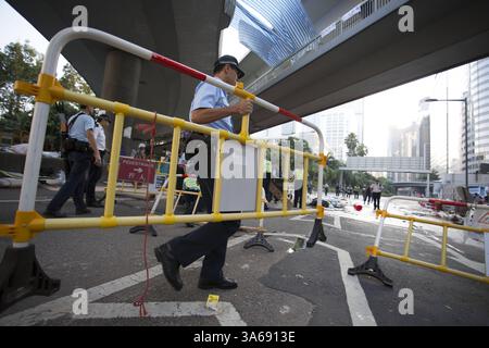 13. Oktober 2014 - Hongkong, China - der Polizeibeamte beginnt am 13. Oktober 2014 mit der Beseitigung der Barrikade in der Admiralität Pro-Democracy Sit-in in Hongkong.die Spannungen in Hongkong sind immer noch hoch, da die Pro-Demokratie-Bewegung die Straßen in Hongkong besetzt hat und offene Wahlen und den Rücktritt von Hongkongs Chef Leung Chun Ying forderte. (Bild: © Raul Ariano/ZUMA Wire/ZUMAPRESS.com) Stockfoto
