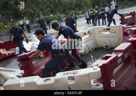 13. Oktober 2014 - Hongkong, China - der Polizeibeamte beginnt am 13. Oktober 2014 mit der Beseitigung der Barrikade in der Admiralität Pro-Democracy Sit-in in Hongkong.die Spannungen in Hongkong sind immer noch hoch, da die Pro-Demokratie-Bewegung die Straßen in Hongkong besetzt hat und offene Wahlen und den Rücktritt von Hongkongs Chef Leung Chun Ying forderte. (Bild: © Raul Ariano/ZUMA Wire/ZUMAPRESS.com) Stockfoto