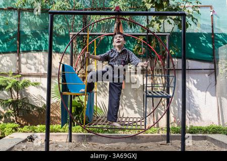 17. November 2014 - Bhopal, Madhya Pradesh, Indien - eines der Kinder des Chingari Trust spielt im Garten. Am 3. Dezember 1984 liefen etwa 40 Tonnen Methylisocyanat-Gas versehentlich aus einer Pestizidfabrik des multinationalen US-amerikanischen Unternehmens Union Carbide Corp. Aus und wurden vom Wind in die umliegenden Slums transportiert. Die Regierung verzeichnete 5.295 Todesfälle. Aktivisten schätzen 25.000 Todesfälle aufgrund von Krankheiten seit dem Leck. Drei Jahrzehnte nach der schlimmsten Industriekatastrophe vergiftet Giftmüll aus der Carbidfabrik der Union immer noch das Gelände von Bhopal. (Kreditbild: © Bernat Parera/ZUMA Wire/ZUMAPRESS.com) Stockfoto