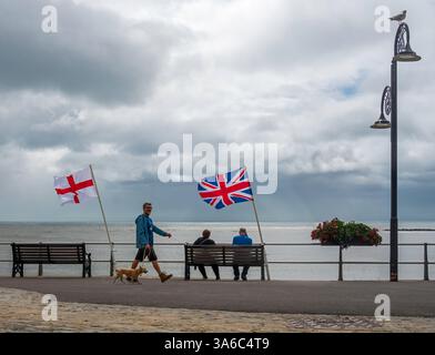 Leute, die entlang der Marine Parade laufen, Lyme Regis, Dorset, England, Großbritannien, an einem stürmischen Tag im August 2023 Stockfoto