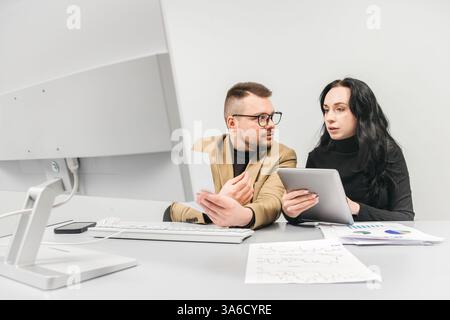 Ein erfahrener Manager oder Unternehmer betreut einen neuen Mitarbeiter im Büro. Das Konzept besteht darin, den Prozess der Mentoring- und Analyse-Analyse zu vermitteln Stockfoto