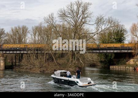 Windsor, Großbritannien. März 2025. Eine Yacht auf der Themse nähert sich der 174 Jahre alten Black Potts Railway Bridge, wo Bahningenieure Gleisausbauten durchführen, die den Abbau alter Schienen und Schwellen und die Installation von über 700 m neuen Gleisen beinhalten. Die South Western Railway (SWR) wird während der geplanten Arbeiten, die eine Woche dauern werden, nicht zwischen Windsor und Staines verkehren. Quelle: Mark Kerrison/Alamy Live News Stockfoto