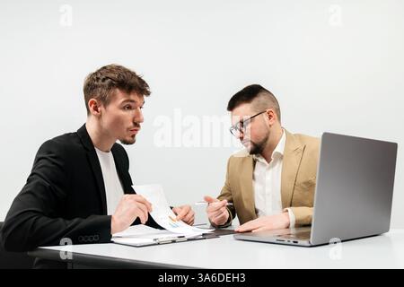 Spezialisten im Büro diskutieren und lösen das Problem rückläufiger Umsätze und Umsätze. Das Konzept besteht darin, Teamarbeit und Analyse zu zeigen Stockfoto