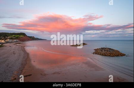 Blick nach Osten vom Aussichtspunkt Sidmouth Beach bei Sonnenuntergang, während die untergehende Sonne die Wolken erhellt. Sidmouth, Devon, England, Großbritannien. Stockfoto