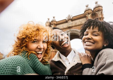 Drei glückliche weibliche Touristen machen ein Selfie in barcelona, mit dem triumphbogen-Denkmal im Hintergrund Stockfoto