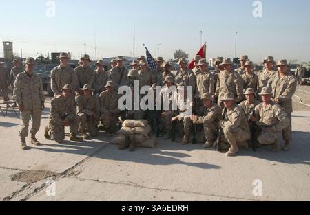 25. August 2004; Mahmudiyah, Irak; Marines aus dem 2. Zug, Kompanie E, 2. Bataillon, 2. Marineregiment, stehen um das zeremonielle Gewehr, Helm, Stiefel und Hundeanhänger. Die Gegenstände stellen einen ihrer eigenen verlorenen im Kampf dar: CPL Christopher W. Belchik, ein Truppenführer der Firma. Er starb am 22. August an Schrapnell-Wunden. Stockfoto