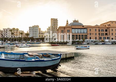 Ein atemberaubender Sonnenuntergang über Porto Vecchio in Bari, Apulien, mit warmen goldenen Tönen auf den historischen Fischerbooten und ruhigen Adria-Gewässern Stockfoto