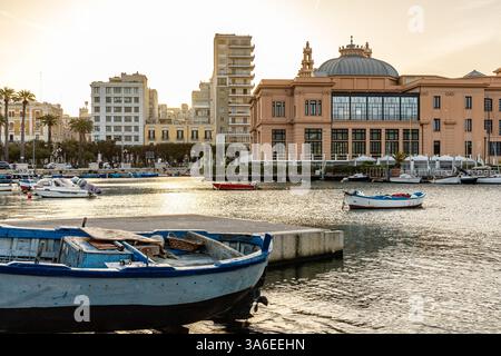 Ein atemberaubender Sonnenuntergang über Porto Vecchio in Bari, Apulien, mit warmen goldenen Tönen auf den historischen Fischerbooten und ruhigen Adria-Gewässern Stockfoto
