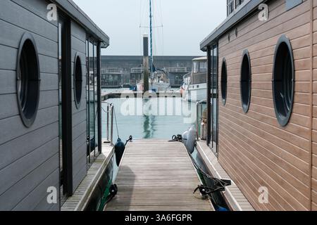 23. März 2025 - Brighton, Großbritannien - kleine Häuser, Hausboote und Boote und Yachten liegen in Brighton Marina an der Südküste Englands Stockfoto