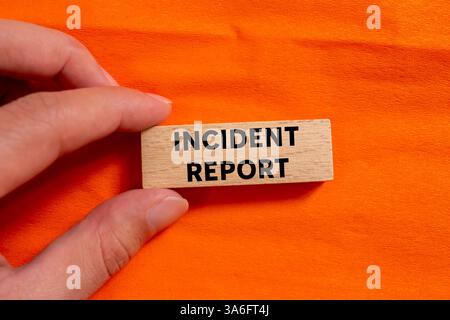 Meldung zum Vorfall auf Holzblock auf orangem Hintergrund geschrieben. Symbol für den konzeptionellen Vorfallbericht. Kopierbereich. Stockfoto