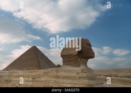 Die berühmte große Sphinx und Pyramide stehen majestätisch unter einem dramatisch bewölkten Himmel Stockfoto