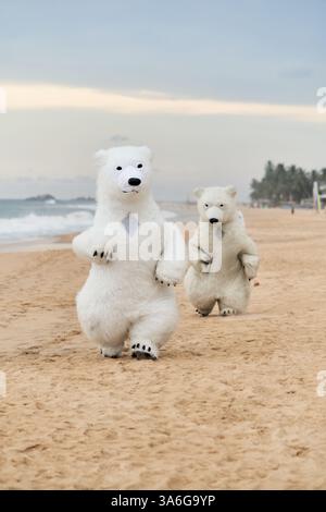 Animateure, die als Eisbären verkleidet sind, unterhalten die Leute am Strand Stockfoto