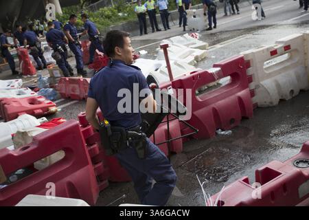 13. Oktober 2014 - Hongkong, China - der Polizeibeamte beginnt am 13. Oktober 2014 mit der Beseitigung der Barrikade in der Admiralität Pro-Democracy Sit-in in Hongkong.die Spannungen in Hongkong sind immer noch hoch, da die Pro-Demokratie-Bewegung die Straßen in Hongkong besetzt hat und offene Wahlen und den Rücktritt von Hongkongs Chef Leung Chun Ying forderte. (Bild: © Raul Ariano/ZUMA Wire/ZUMAPRESS.com) Stockfoto