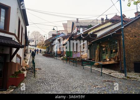 Sarajevo, Bosnien - 2. Dezember 2022: Eine charmante und malerische Kopfsteinpflasterstraße mit lebhaften, farbenfrohen Geschäften und Boutiquen Stockfoto
