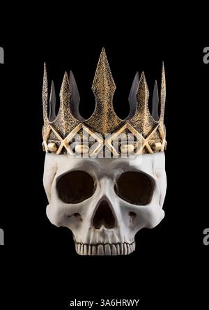 Menschlicher Schädel mit alter goldener Krone isoliert auf schwarzem Hintergrund Stockfoto