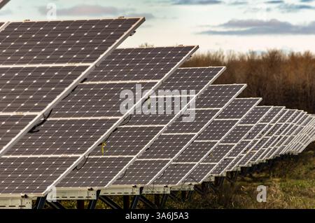 Solarpaneel-Array in einem offenen Feld mit abgewinkelten Paneelen in den Hintergrund Stockfoto