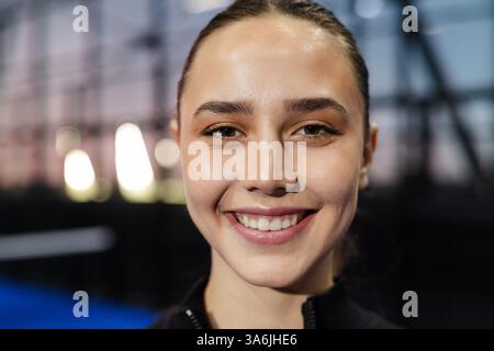 Lächelnde Frau genießt Padel-Tennis-Match auf einem modernen Hallenplatz Stockfoto