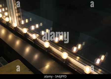 Weiße Lichter sind unscharf und reflektieren im Glas. Neonlichter. Stockfoto