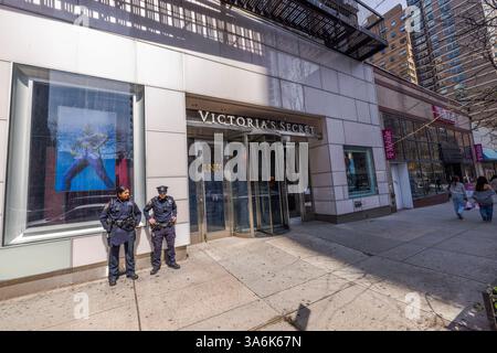 Polizeibeamte stehen vor Victoria's Secret Eingang an sonnigen Tagen in der Stadt mit T Mobile Store im Hintergrund. New York. USA. Stockfoto