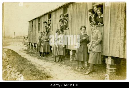 Original-Postkarte aus der Zeit des 1. Weltkriegs von weiblichen Mitgliedern des Women's Army Auxiliary Corps (WAAC) aus einem WAAC-Album. Die Frauen, vielleicht in einer medizinischen Einrichtung, sind in Uniform entspannen, stehen außerhalb ihrer Wohnräume. Einige scheinen Briefe zu lesen. Auf der Rückseite steht "Hütte 22 Camp, Etaples". WW1 weibliche Kriegsarbeiterinnen. Etaples, Nordfrankreich, Um 1917 /1918. Stockfoto