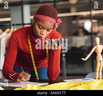 Tonnotiz beim Zeichnen, Afroamerikanerin im Modestudio Stockfoto