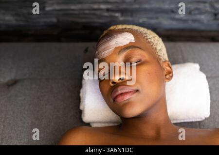 Frau zu Hause, die eine Gesichtsbehandlung erhält, die Augen geschlossen und friedlich ausgeruht Stockfoto
