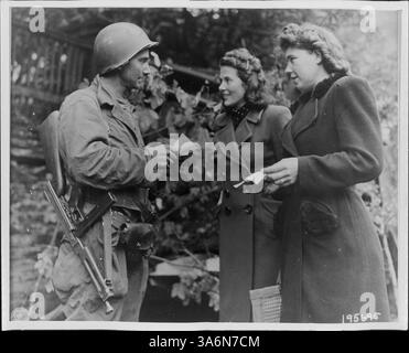 T/4 Kellen, eine Minnesotanin aus Woodstock, überprüft die Zulassungsscheine zweier deutscher Frauen, die während des Zweiten Weltkriegs durch den Stadtrand von Monschau fahren Stockfoto