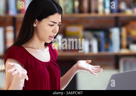 Verwirrt Asiatische Frau Mit Problemen Mit Laptop Während Der Arbeit Aus Der Ferne Im Café Stockfoto
