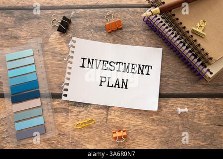 Ein farbiger Holzblock mit Text INVESTITIONSPLANUNG neben weißem Wecker. Geschäfts- und Finanzplanungskonzept Stockfoto