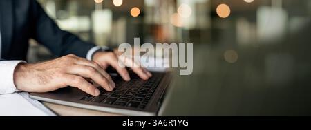 Geschäftsmann, der ein Notebook benutzt, auf der Tastatur tippt, E-Mails schreibt, am Schreibtisch im Büro sitzt, selektive Fokussierung Stockfoto