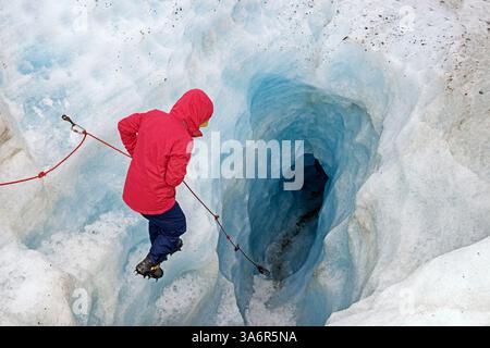 Bergsteiger, der in eine Gletscher-Eishöhle hinabsteigt, Fox Glacier, Westland National Park, South Island, Neuseeland Stockfoto