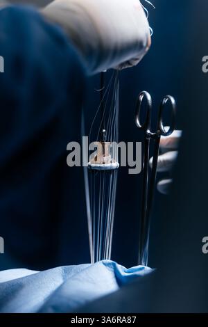 Team erfahrener Chirurgen, die eine komplexe Herzoperation mit voller Konzentration in einem gut beleuchteten Operationssaal durchführen. Technologie in der Kardiologie Stockfoto