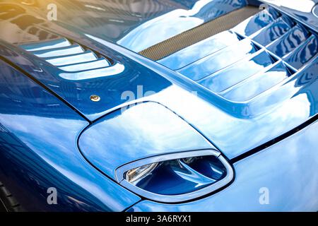 Modernes blaues Auto Nahaufnahme von Scheinwerfern und Sonnenstrahlen. Stockfoto