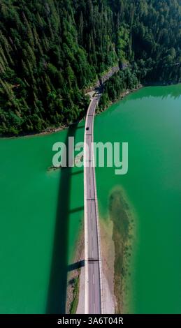 Blick aus der Vogelperspektive auf die Brücke über den Sylvenstein See, früh am Morgen an einem sonnigen Tag im Sommer. Stockfoto
