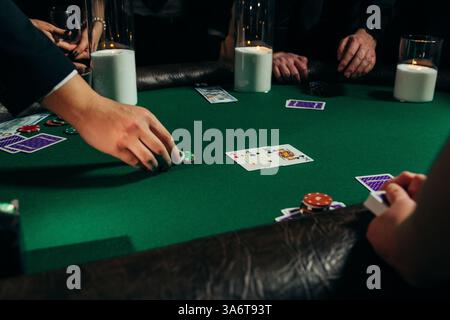 Leute spielen Poker auf einer Abendparty, Unterhaltung. Blick auf Hände und Tisch Stockfoto