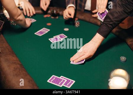 Leute spielen Poker auf einer Abendparty, Unterhaltung. Blick auf Hände und Tisch Stockfoto