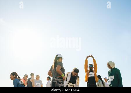 Eine Gruppe von Läufern zieht sich unter klarem Himmel zusammen und bereitet sich auf einen Marathon vor. Die Teilnehmer zeigen Enthusiasmus und Energie und konzentrieren sich auf den Stockfoto