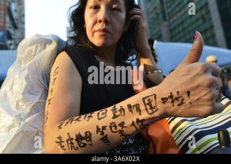 7. Oktober 2014 - Hongkong, China - JOYCE HO, die sagt, sie sei seit drei Tagen in Folge eine Unterstützerin der Demonstranten in Hongkong gewesen, zeigt ein "Tattoo", das auf Chinesisch die Hongkonger Chefin Leung Chun-Ying dazu auffordert, "in den Zoo zurückzukehren. Die Tigerfrau wartet auf dich." Ho wird beim Besuch der pro-demokratischen Proteststätte in Mong Kok gesehen. (Bild: © Chris Stowers/TNS/zReportage.com via ZUMA Press) Stockfoto