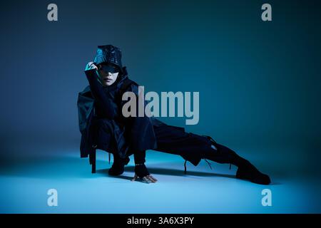 Ein stilvoller asiatischer Mann trifft eine einzigartige Pose in einer dramatischen Umgebung. Stockfoto