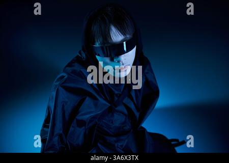 Ein stilvoller asiatischer Mann mit schwarzer Sonnenbrille hebt sich vor einem auffälligen blauen Hintergrund ab. Stockfoto