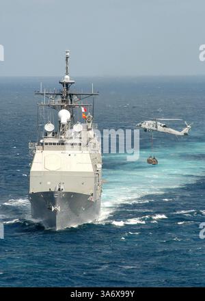 1. Juli 2004; Atlantischer Ozean; ein MH-60S KnightHawk, der den Chargers der Helicopter Combat Support Squadron (HC-6) zugeordnet ist, überträgt während einer vertikalen Auffüllung mit dem schnellen Kampfflugzeug USS Detroit (AOE 4) Fracht an den Lenkraketenkreuzer USS Gettysburg (CG 64). Gettysburg wird als Teil der USS Enterprise (CV 65) Carrier Strike Group (CSG) eingesetzt. Die Enterprise CSG ist eine von sieben Teilnehmern am Summer Pulse 2004. Summer Pulse 2004 ist der gleichzeitige Einsatz von sieben Aircraft Strike Groups (CSGs), die die Fähigkeit der Navy demonstrieren, glaubwürdige comba bereitzustellen Stockfoto